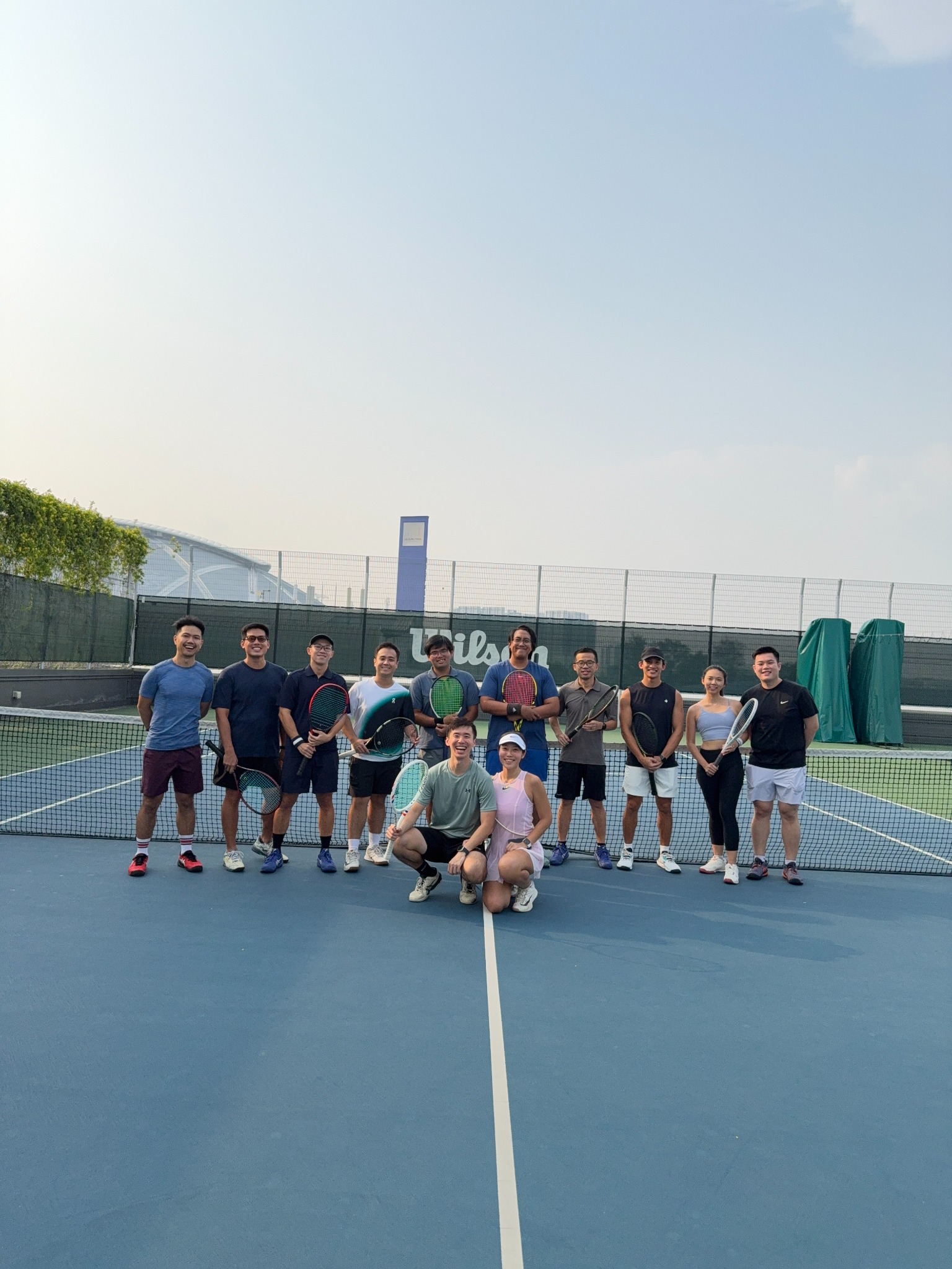AdSide tennis players gathered together on court